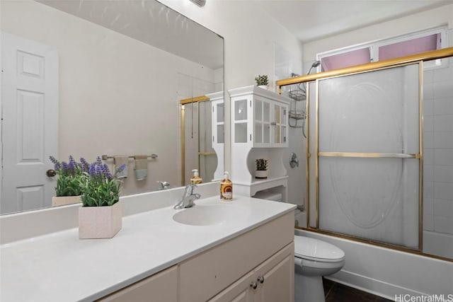 full bathroom featuring tile patterned flooring, toilet, vanity, and combined bath / shower with glass door