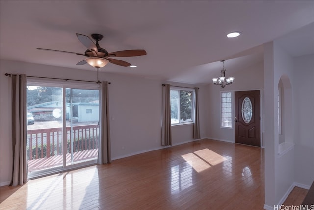 foyer entrance featuring ceiling fan with notable chandelier and light wood-type flooring