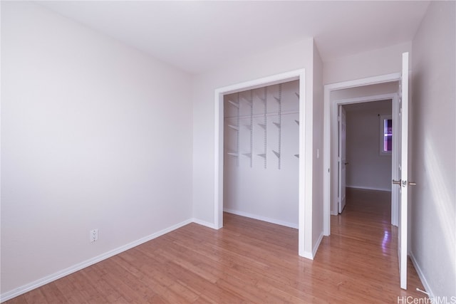 unfurnished bedroom featuring a closet and light hardwood / wood-style floors