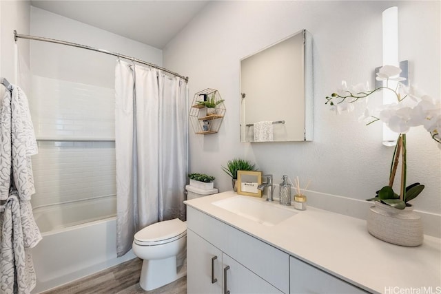 full bathroom featuring hardwood / wood-style floors, vanity, toilet, and shower / tub combo with curtain