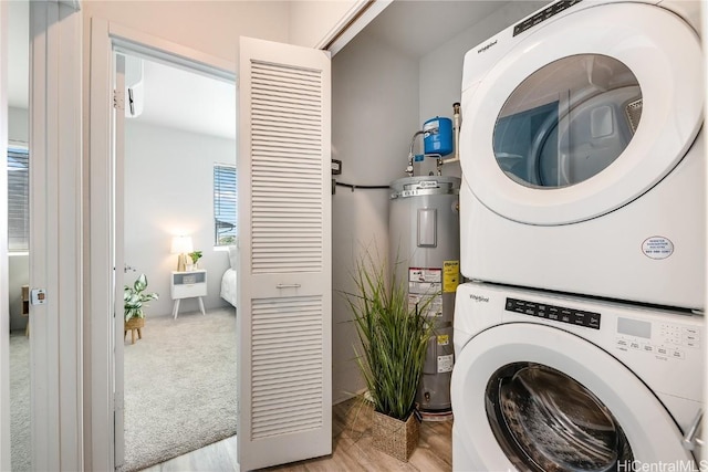 washroom with light wood-type flooring, electric water heater, and stacked washer and clothes dryer