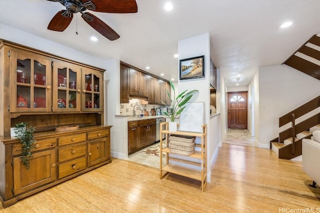 kitchen featuring ceiling fan, dishwasher, sink, and light hardwood / wood-style flooring