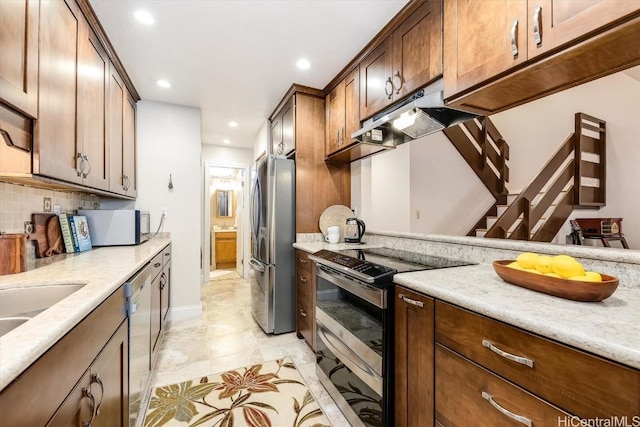 kitchen with tasteful backsplash, light stone countertops, light tile patterned flooring, and appliances with stainless steel finishes