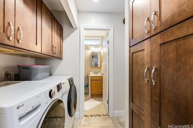 clothes washing area with cabinets, sink, and washing machine and clothes dryer