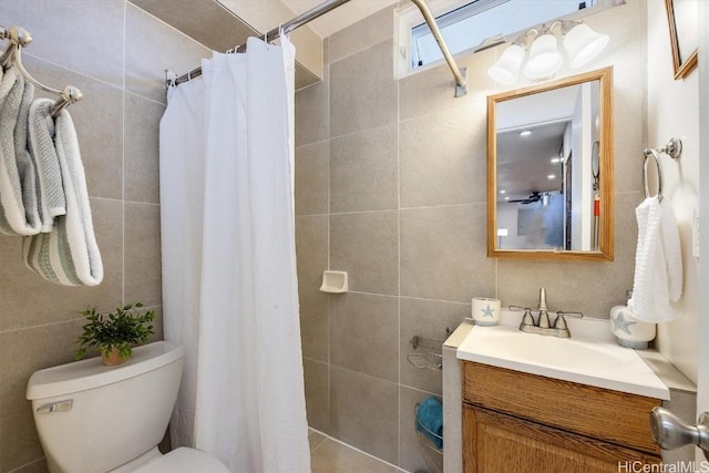 bathroom featuring a shower with shower curtain, vanity, toilet, and tile walls