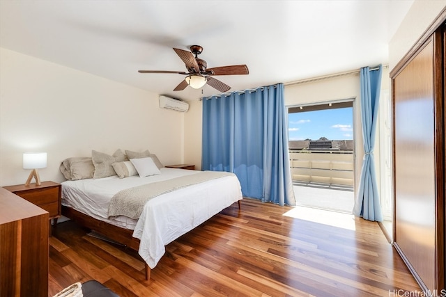 bedroom with dark hardwood / wood-style flooring, access to outside, a wall unit AC, ceiling fan, and a closet