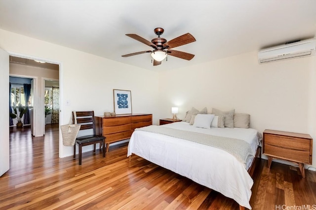 bedroom featuring ceiling fan, wood-type flooring, and a wall mounted air conditioner