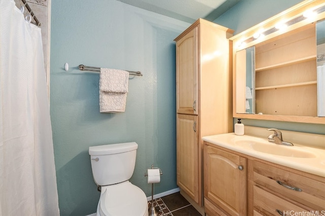 bathroom with tile patterned flooring, vanity, and toilet