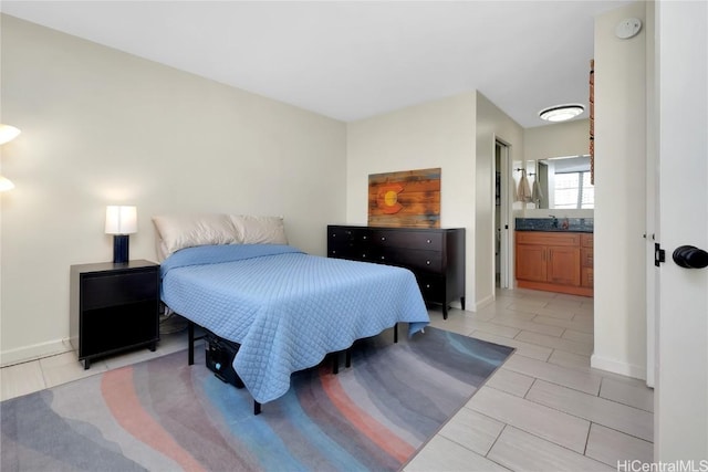 bedroom with connected bathroom and sink