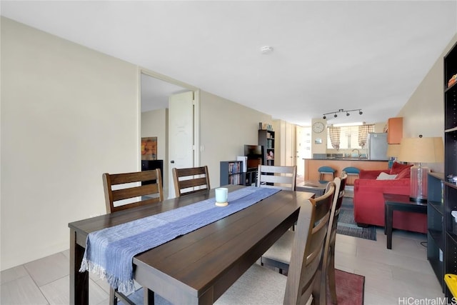 dining room with rail lighting and sink