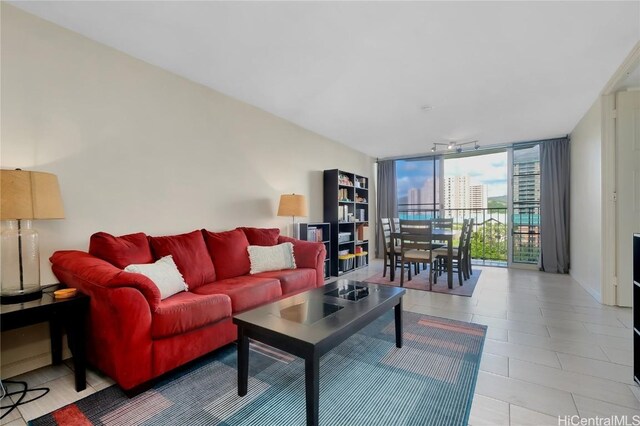 living room with light tile patterned floors and a wall of windows