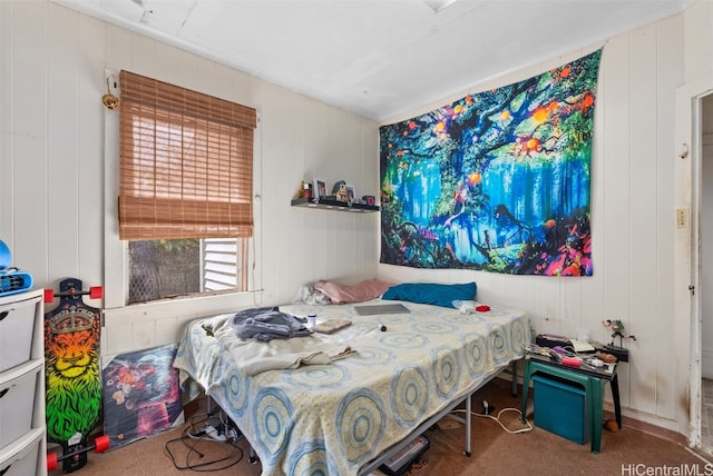 carpeted bedroom featuring wooden walls