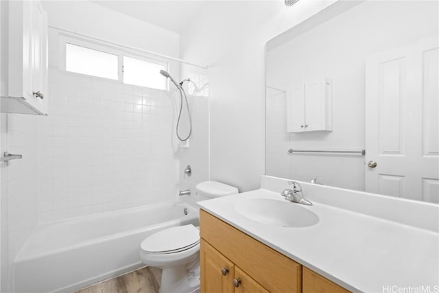 full bathroom featuring hardwood / wood-style floors, vanity, toilet, and tiled shower / bath