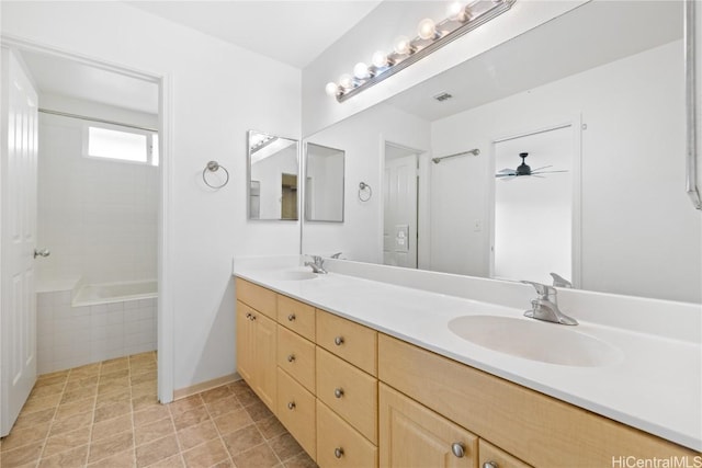 bathroom featuring vanity, tile patterned floors, ceiling fan, and tiled tub