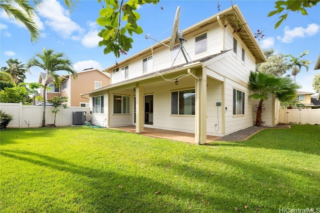 back of property with cooling unit, a patio area, and a lawn