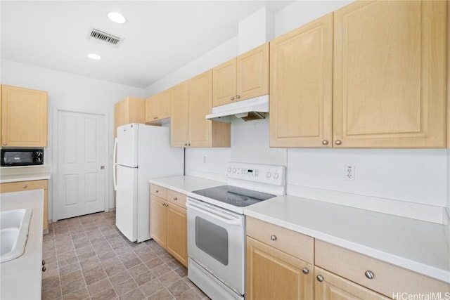 kitchen with light brown cabinets, white appliances, and sink