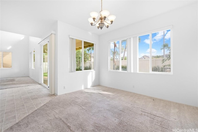 unfurnished room featuring light colored carpet and an inviting chandelier