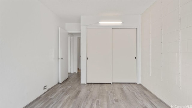 unfurnished bedroom with light hardwood / wood-style floors and a closet