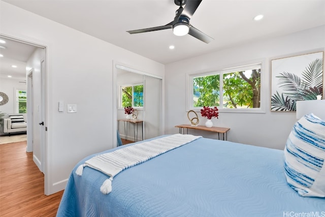 bedroom with hardwood / wood-style flooring, ceiling fan, and a closet