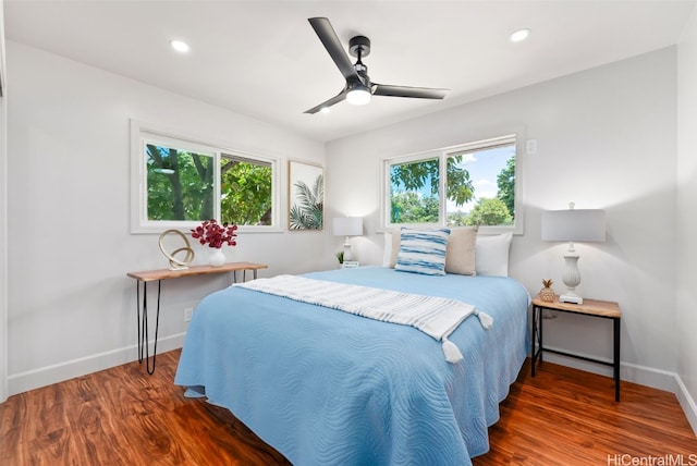 bedroom featuring multiple windows, dark wood-type flooring, and ceiling fan