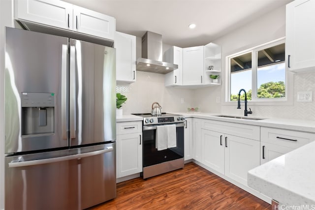 kitchen with white cabinets, wall chimney range hood, sink, dark hardwood / wood-style flooring, and stainless steel appliances