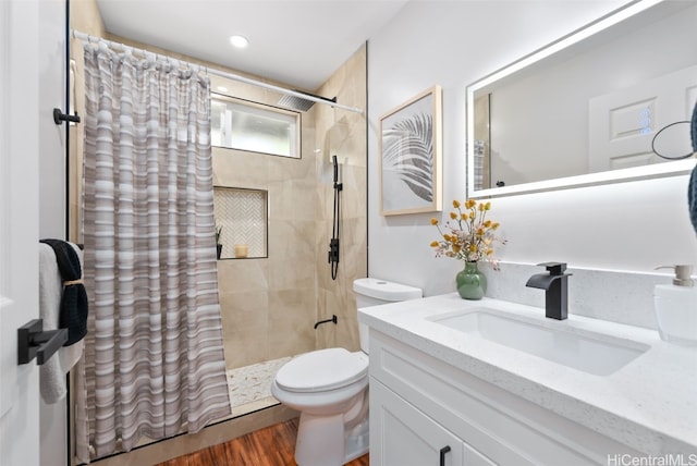 bathroom featuring walk in shower, toilet, vanity, and hardwood / wood-style flooring