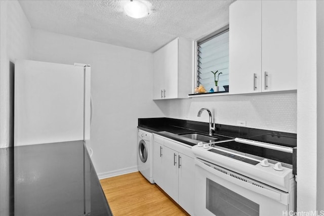 kitchen with light hardwood / wood-style floors, sink, white cabinets, washer / clothes dryer, and white range with electric cooktop