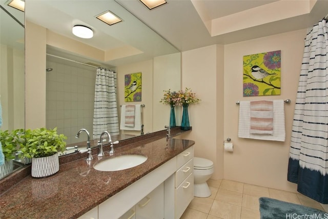 bathroom with walk in shower, vanity, a raised ceiling, tile patterned flooring, and toilet