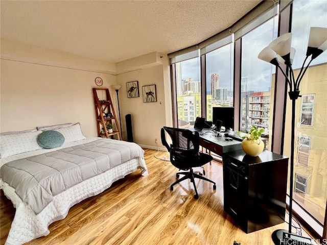 bedroom featuring light hardwood / wood-style flooring and a textured ceiling