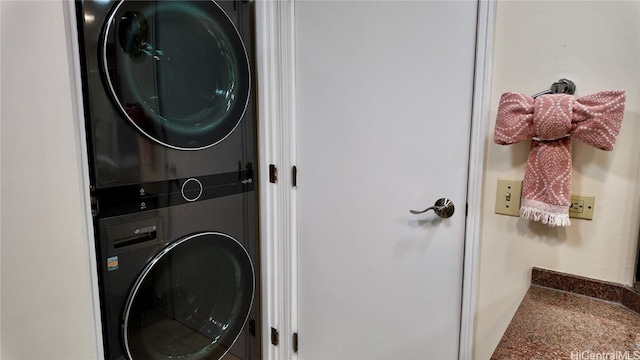 washroom with stacked washing maching and dryer