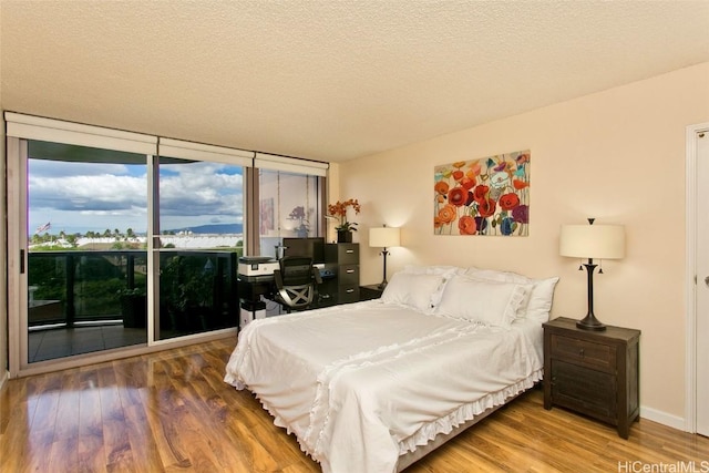 bedroom with wood-type flooring and a textured ceiling