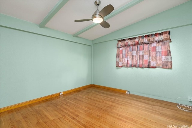 spare room featuring ceiling fan, hardwood / wood-style floors, and vaulted ceiling with beams