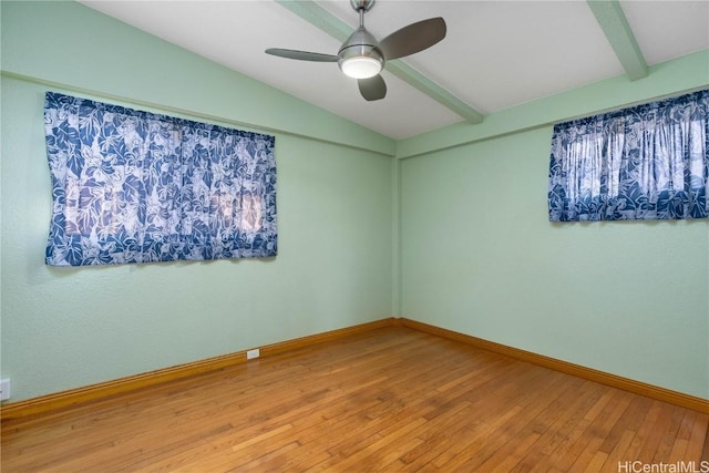 empty room with lofted ceiling with beams, hardwood / wood-style floors, and ceiling fan