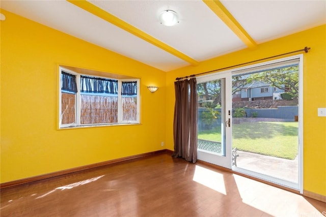 empty room featuring hardwood / wood-style flooring and lofted ceiling