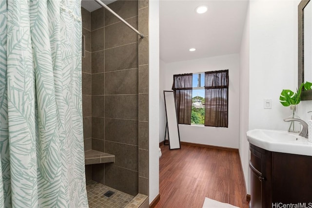 bathroom with walk in shower, vanity, and hardwood / wood-style flooring