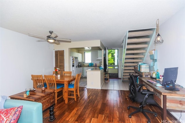 dining area featuring ceiling fan, dark wood-type flooring, and a textured ceiling