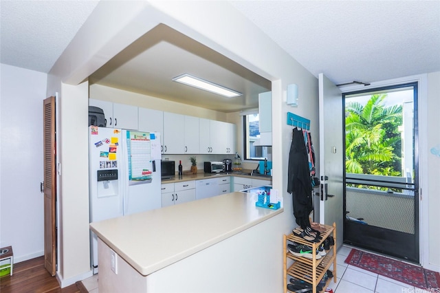 6770 Hawaii Kai Dr Unit 24, Honolulu, HI 96825 - kitchen featuring white appliances, white cabinets, a peninsula, a textured ceiling, and light countertops