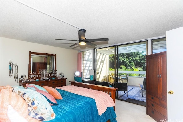 carpeted bedroom with access to exterior, ceiling fan, and a textured ceiling