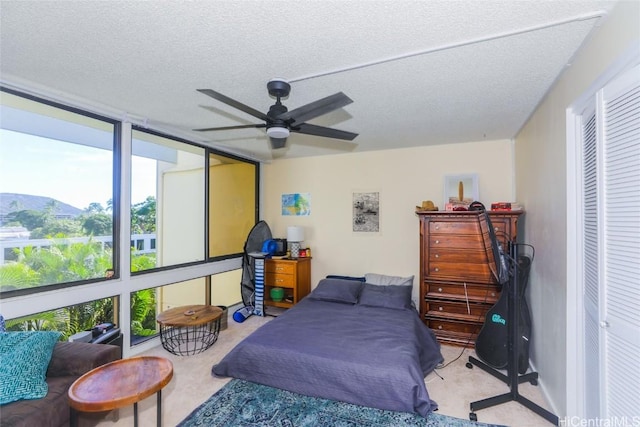 bedroom with a textured ceiling, a closet, and ceiling fan