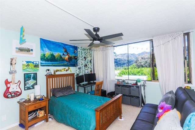 carpeted bedroom with a textured ceiling and ceiling fan