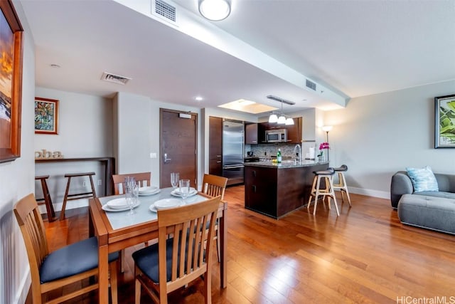 dining area featuring sink and light hardwood / wood-style flooring