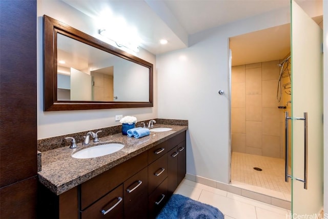 bathroom with tile patterned floors, vanity, and tiled shower