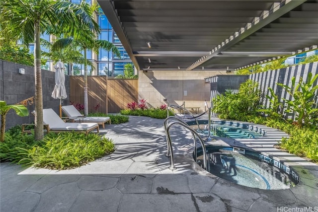 view of patio featuring an in ground hot tub