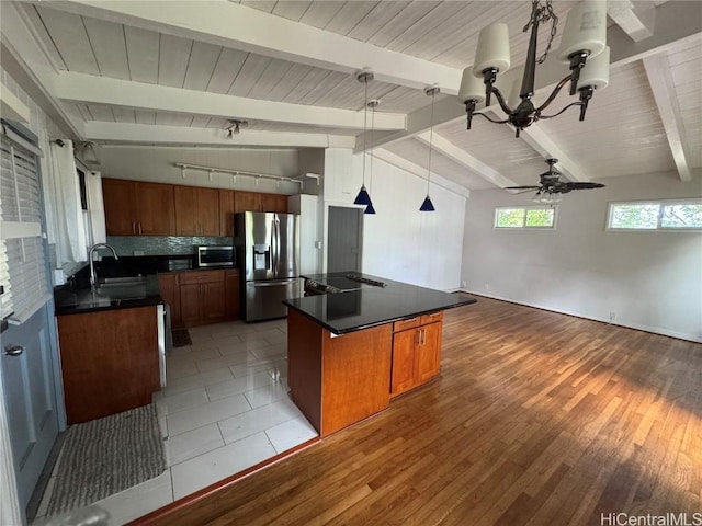 kitchen with a center island, ceiling fan with notable chandelier, decorative light fixtures, wood-type flooring, and stainless steel appliances