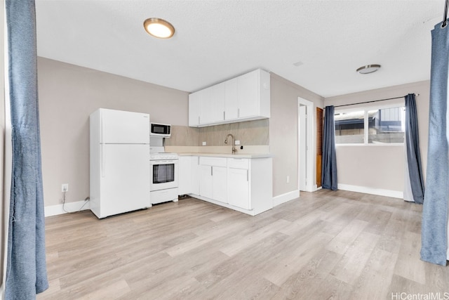 kitchen featuring light hardwood / wood-style floors, white cabinetry, white appliances, and sink