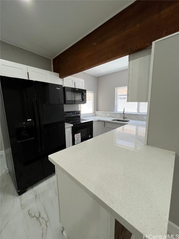 kitchen with kitchen peninsula, sink, white cabinets, and black appliances