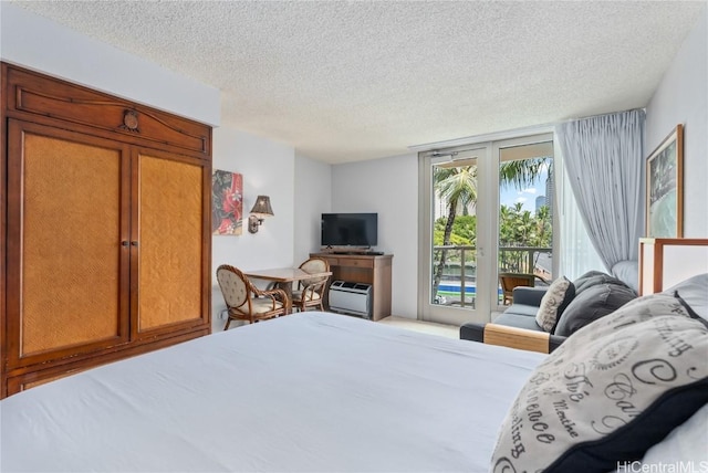 bedroom with access to exterior and a textured ceiling