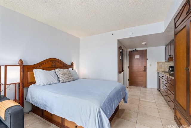 tiled bedroom with a textured ceiling, ensuite bath, and sink