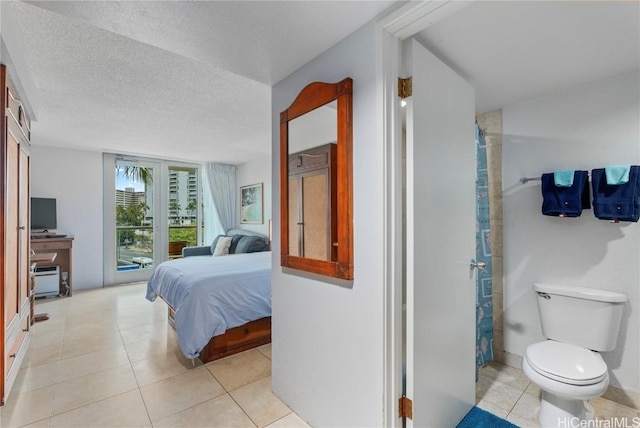 tiled bedroom featuring access to exterior and a textured ceiling