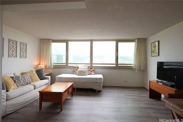 bedroom featuring multiple windows, a textured ceiling, and hardwood / wood-style flooring